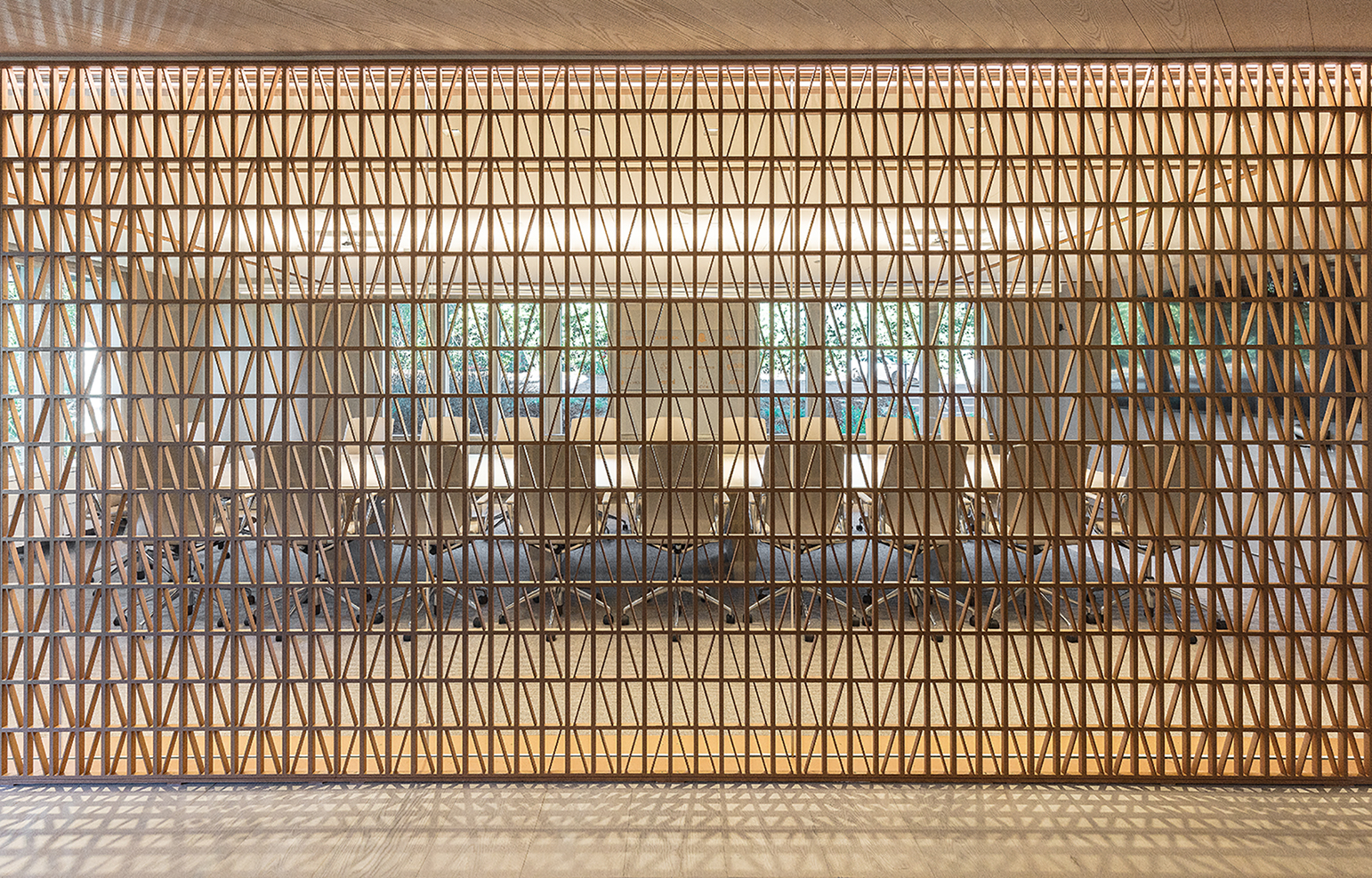Bronze screens between conference rooms and corridors are backlit to create a play of light and shadow.